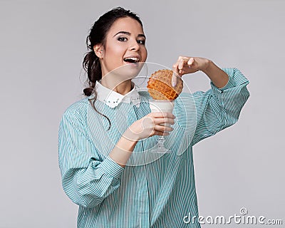 Young brunette wetting a cookie in a glass of milk Stock Photo