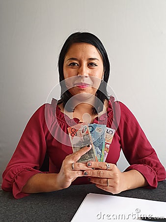 young brunette woman grabbing and showing Australian money Stock Photo