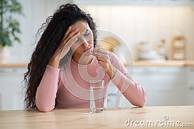 Young brunette woman suffering from headache or migraine at home Stock Photo