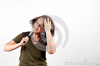 Young brunette woman with tangled unruly hair holding comb Stock Photo