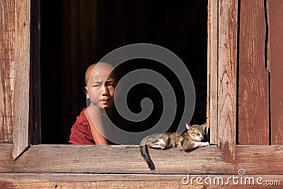 Young buddhist monks laughing at a window Editorial Stock Photo