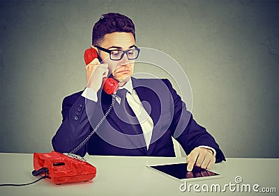 Business man having serious telephone conversation and using tablet computer Stock Photo