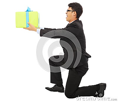 Young Business man holding a gift box and kneel. Stock Photo