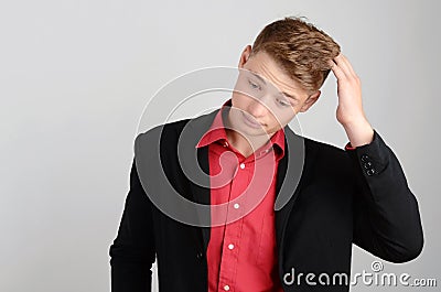 Young business man holding his head down frowning. Man thinking. Stock Photo