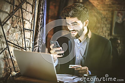 Young business man using smart phone to pay bills online. Stock Photo