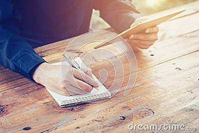 Young business man writing note pad and using tablet in coffee s Stock Photo