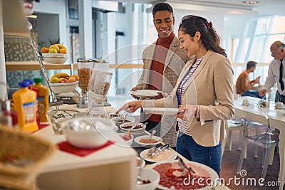 Young business people are enjoying in self service of delicious food at the canteen. Business, people, company Stock Photo