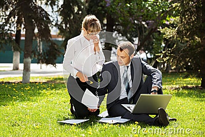 Young business people with laptop in a city park Stock Photo