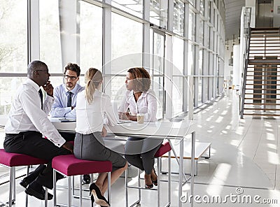 Young business people talking in modern lobby, full length Stock Photo