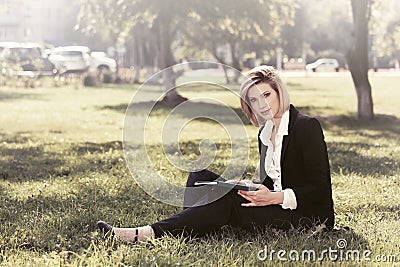 Young business woman with a folder in a city park Stock Photo