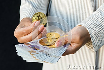 Young business woman holding British pounds and bitcoin in hands, close up of female hands with cash equivalents Stock Photo