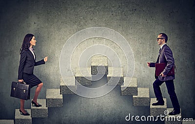 Young business woman and man stepping up a stairway career ladder Stock Photo