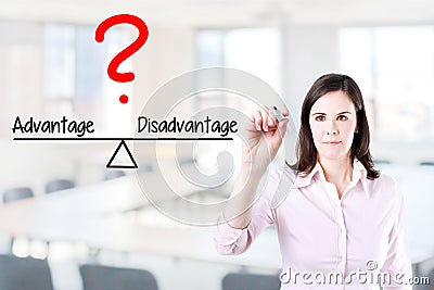 Young business woman writing advantage and disadvantage compare on balance bar. Office background. Stock Photo