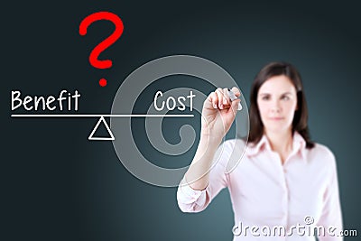 Young business woman writing cost and benefit compare on balance bar. Blue background. Stock Photo