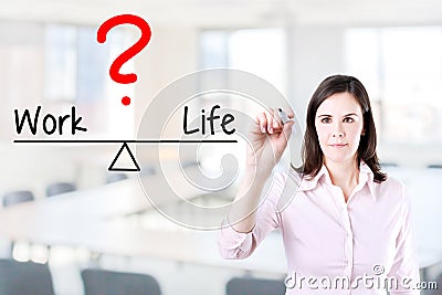 Young business woman writing life and work compare on balance bar. Office background. Stock Photo