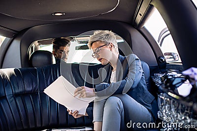 Young business woman and her chauffeur in limo Stock Photo