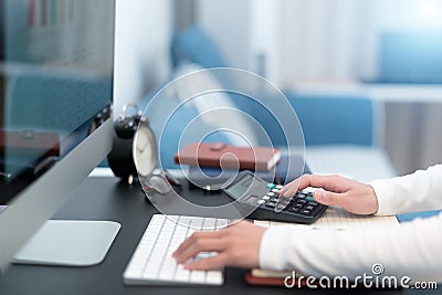 Young business women work with calculator and computer desktop on the modern work table at home office Stock Photo