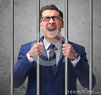 Young businessman behind the bars in prison Stock Photo