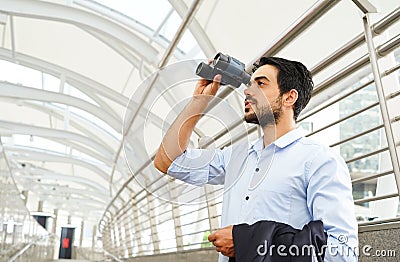 Young businessman with binoculars looking for opportunity to develop business in the future Stock Photo