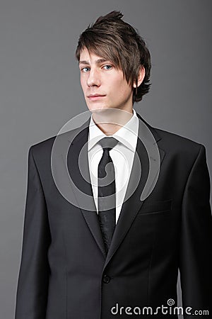 Young businessman black suit casual tie on gray background Stock Photo