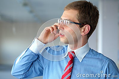 Young businessman in blue shirt talks over mobile Stock Photo