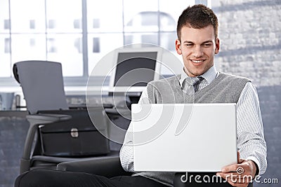 Young businessman browsing internet smiling Stock Photo