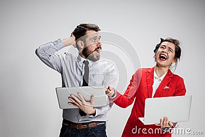 The young businessman and businesswoman with laptops communicating on gray background Stock Photo