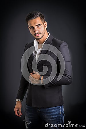 Young businessman confidently posing on dark background Stock Photo