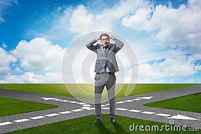 The young businessman at crossroads in uncertainty concept Stock Photo