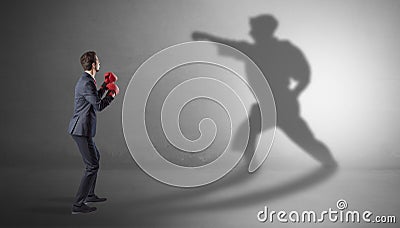 Young businessman fighting with his shadow Stock Photo