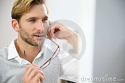 Young businessman in front of desktop computer Stock Photo