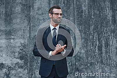 A young businessman with glasses and a beard claps his hands Stock Photo