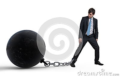 Young businessman has chained big metal ball to his leg. Isolated on white background. Stock Photo