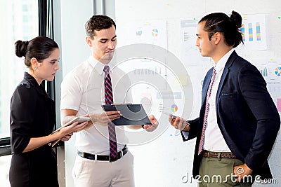 Young businessman holding clipboard with present profit and secretary while giving presentation Stock Photo