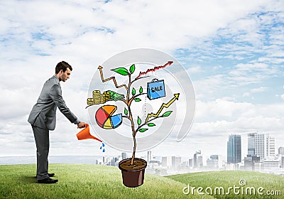 Young businessman outdoors watering drawn growth concept with can Stock Photo