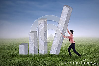 Young businessman pushing a bar chart outdoor Stock Photo