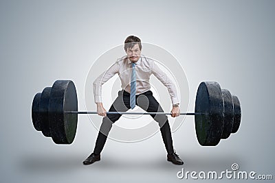 Young businessman in shirt is lifting heavy weights. Stock Photo