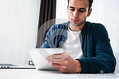 Young businessman sits by table and make business plan using notepad and pen Stock Photo