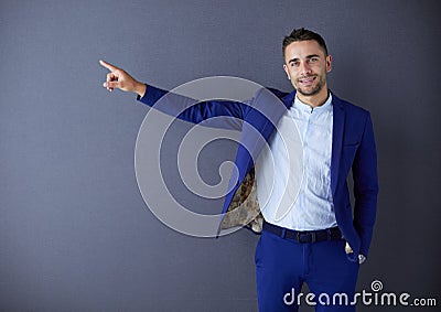 Young businessman sitting isolated on grey background. Stock Photo