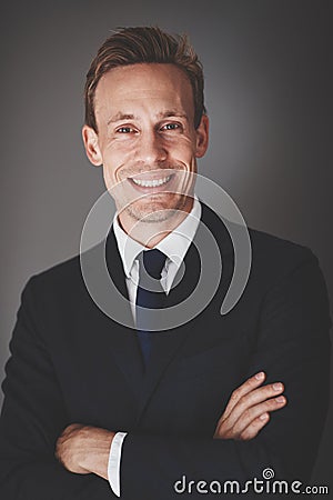 Young businessman smiling confidently while standing against a g Stock Photo