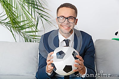 Young businessman sport fan watching match looking camera smiling Stock Photo