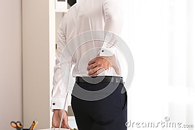 Young businessman suffering from back pain in office Stock Photo