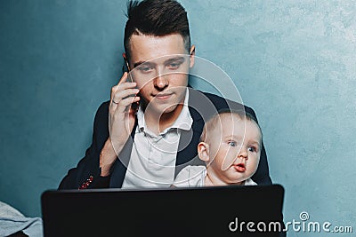 Businessman working at home watching baby daughter Stock Photo