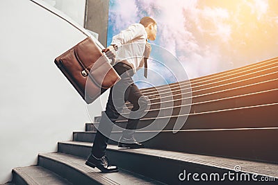 Young businessman upstair on steps to future. Stock Photo