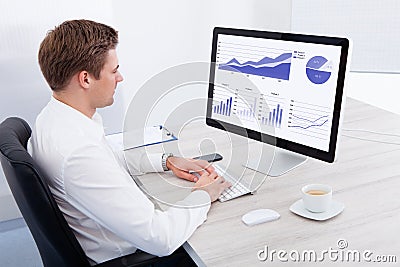 Young businessman using computer at desk Stock Photo