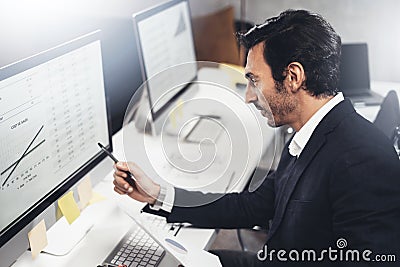 Young businessman using computer at workplace. Professional experienced manager.Horizontal.Blurred background. Stock Photo