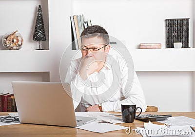 Young businessman using laptop at home. Man working on computer at house. Casual entrepreneur feeling excited about new project Stock Photo