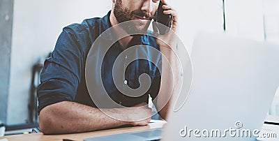 Young businessman using smartphone at office and making notes.Blurred background.Horizontal wide.Cropped. Stock Photo