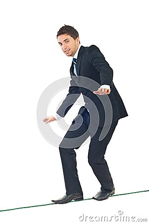 Young businessman walking on tightrope Stock Photo