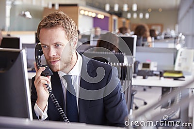 Young businessman at work in a busy, open plan office Stock Photo